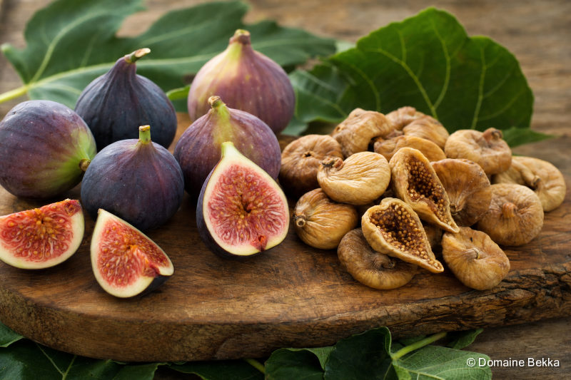 Figues fraîches et figues sèches côte à côte, feuilles de figuier
