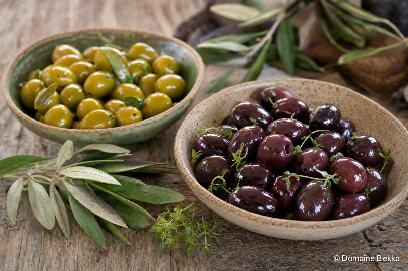 Deux bols d’olives de table, vertes et noires, feuilles d’olivier